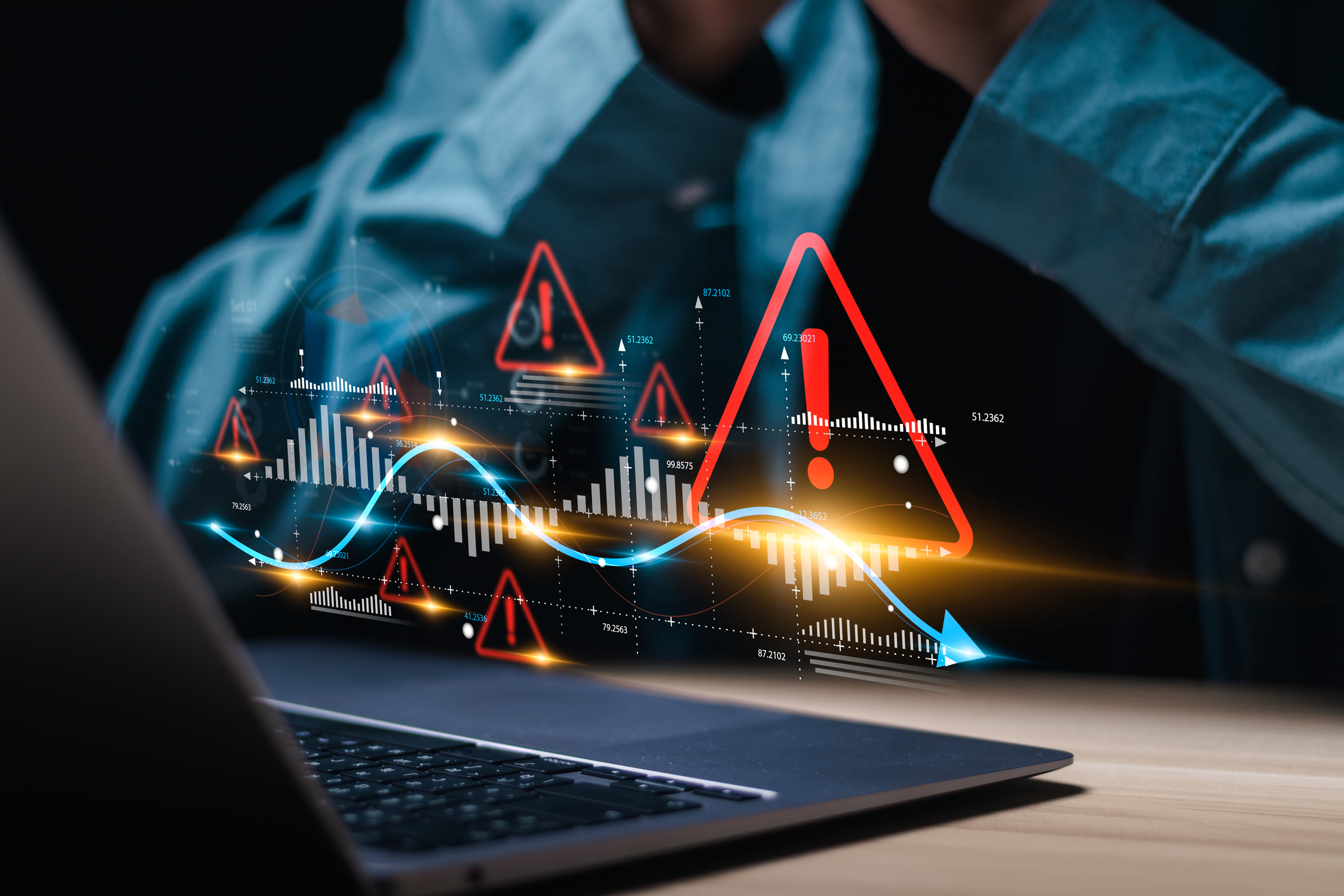 businessman use laptop with virtual world economic growth chart with red warning sign for caution in investing economic situation warning, business investment risks.