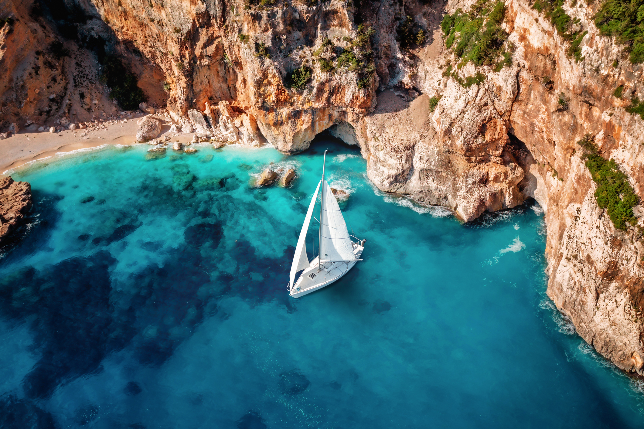 aerial view of sailing yacht in blue bay
