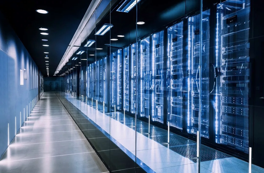 Interior of a high-density data center with rows of illuminated server racks