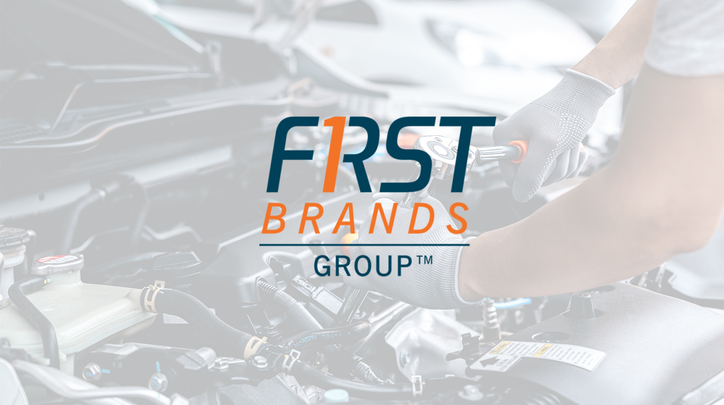 First Brands Group logo over automotive manufacturing and repair environment