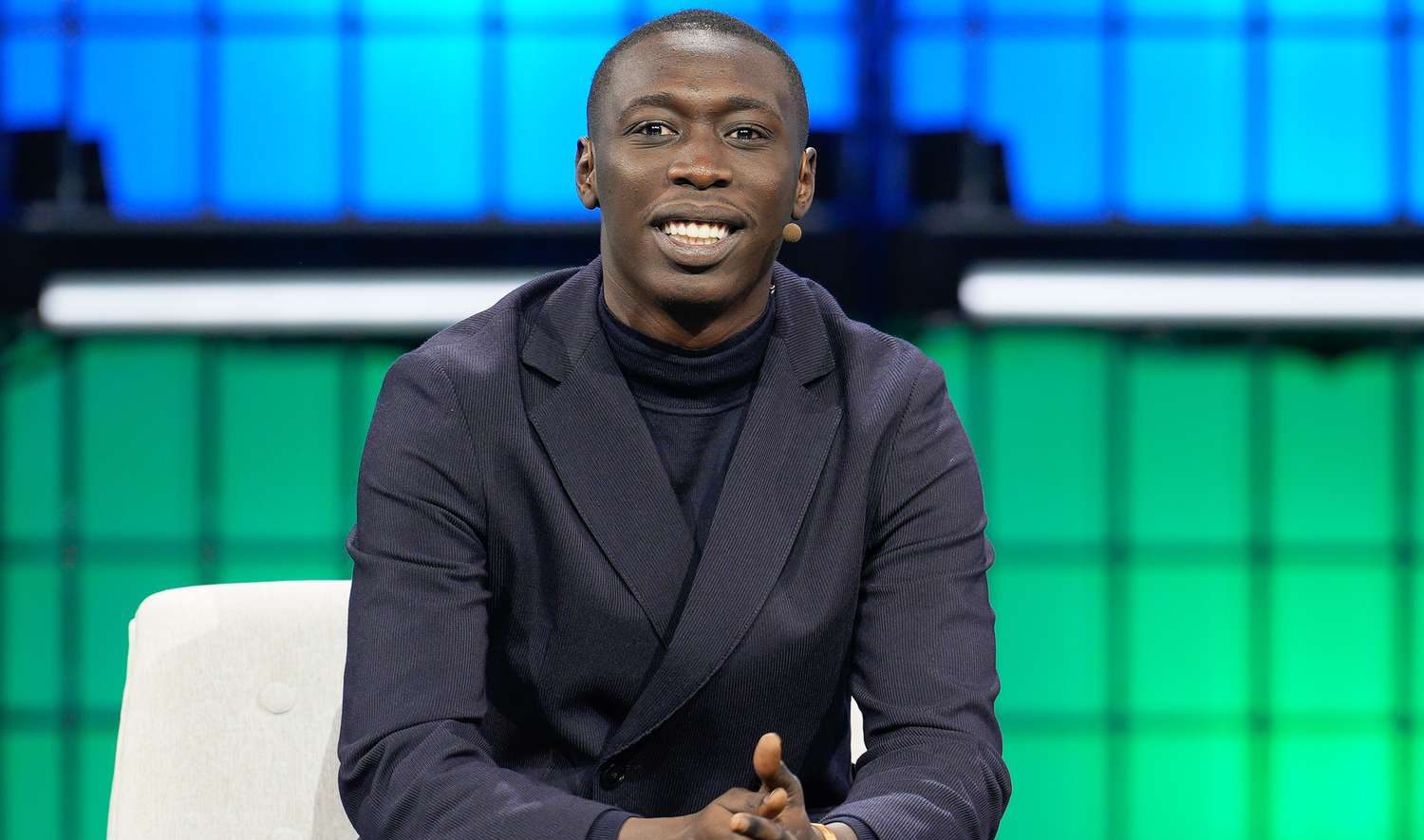 Khaby Lame speaking onstage at a public event amid attention on a major business deal