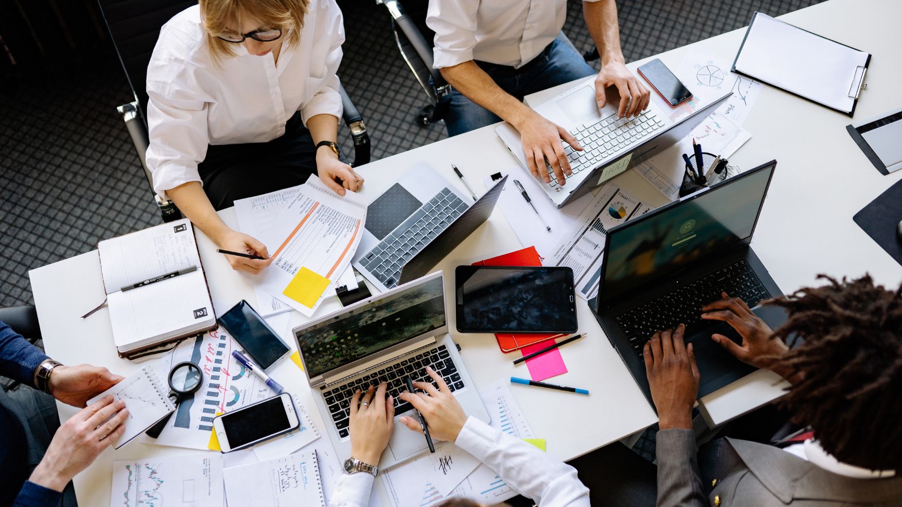 People working around a table on laptops
