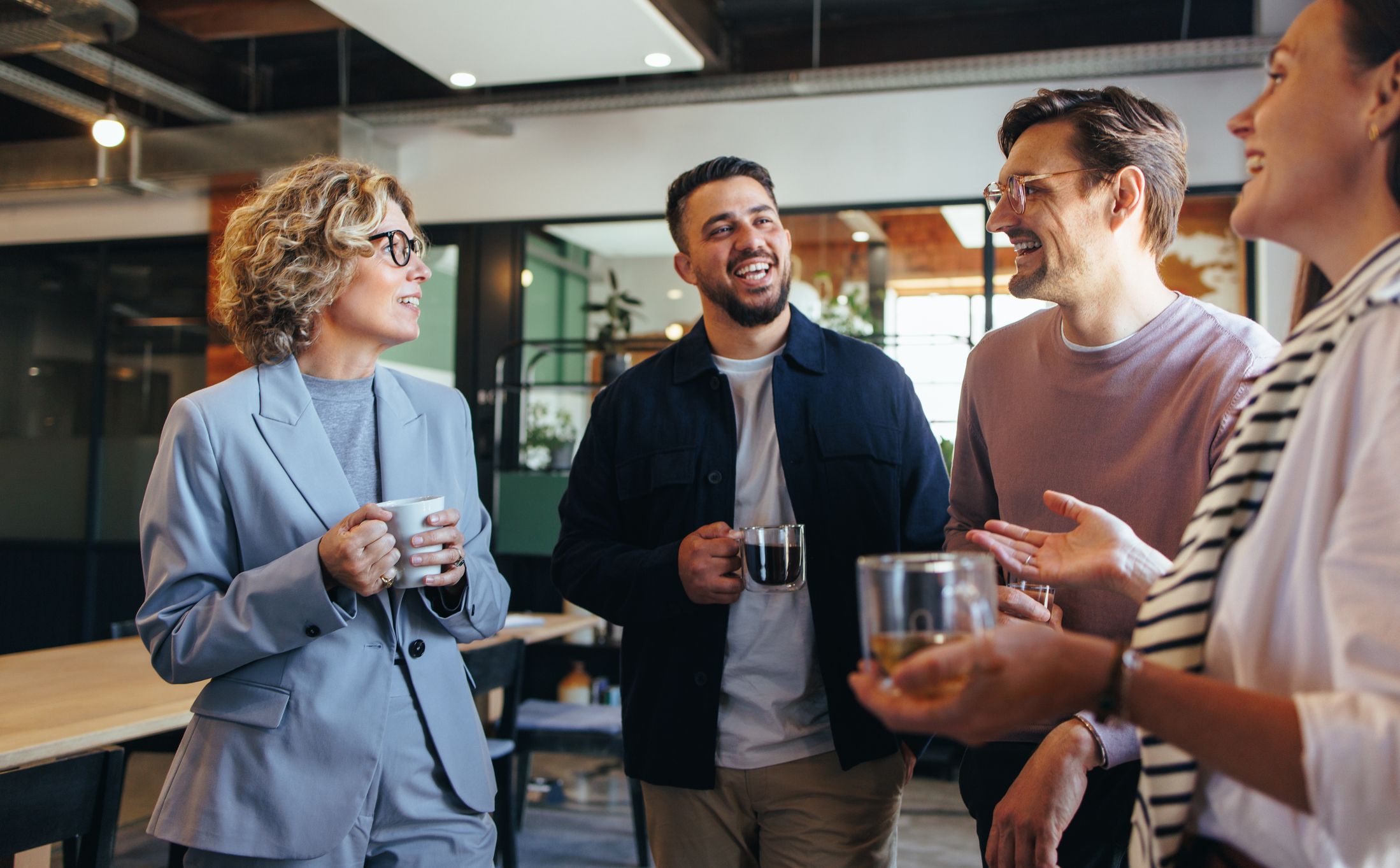 happy colleagues having a coffee break in an office