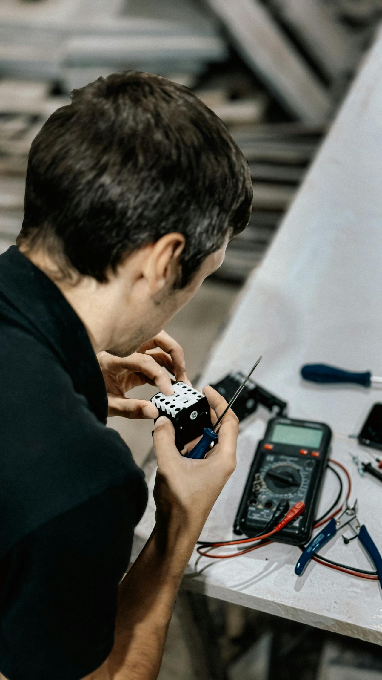 Man Repairing Electronic Device in Workshop Setting